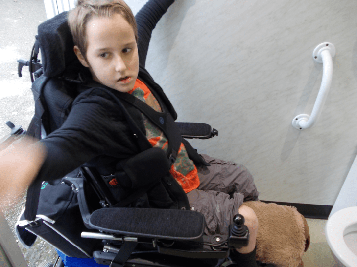 Boy using a powered wheelchair. He is unable to get in the 