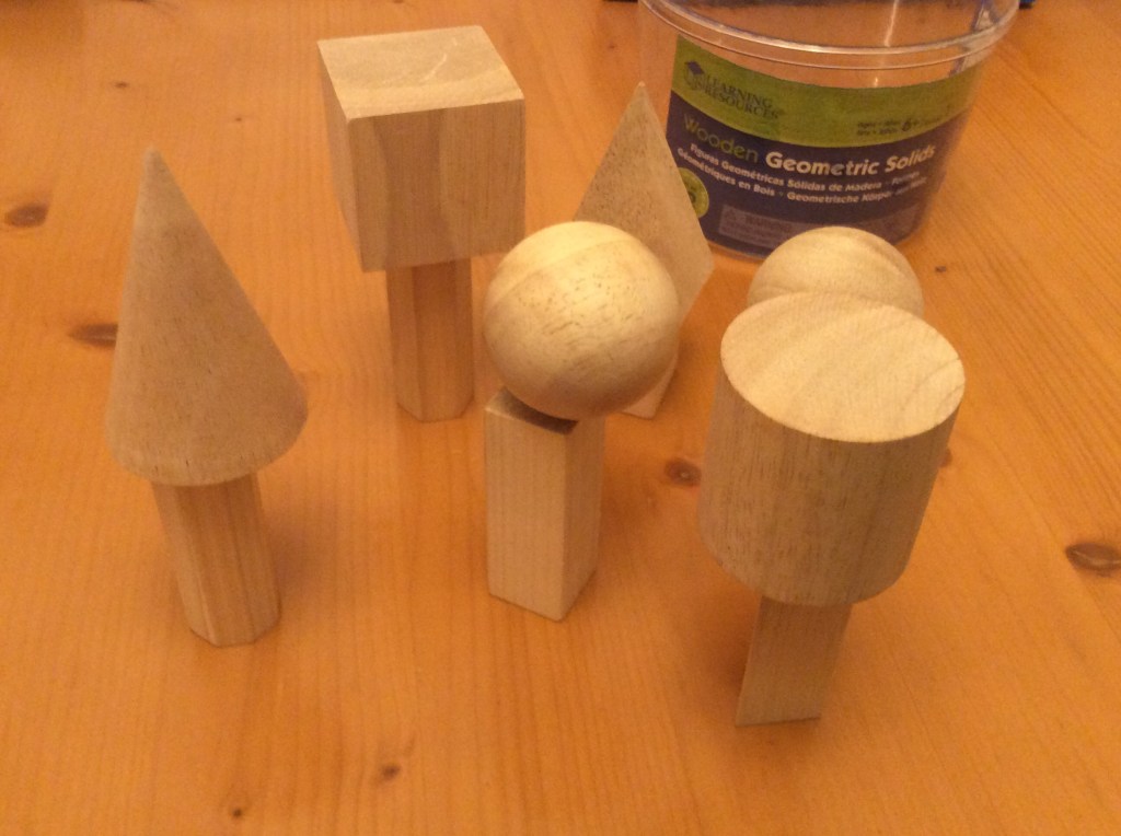 Some wooden geometric solids, placed on top of each other to resemble trees.